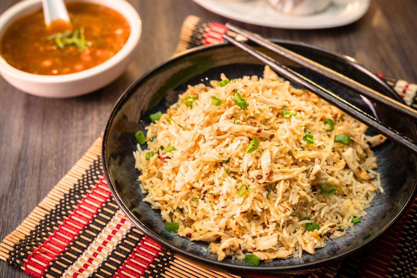 a bowl of fried rice with chopsticks on top of a table